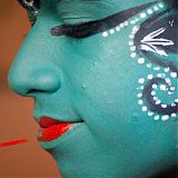 A Kathakali performer carefully applying makeup