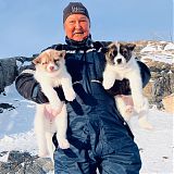 Local hunter with his sledge dog puppies