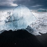 Waves smashing against ice blocks on the black Breiðamerkursandur beach
